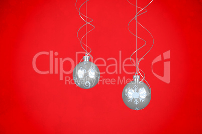 Composite image of two hanging silver bauble decorations