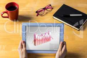 Composite image of businesswoman using tablet at desk