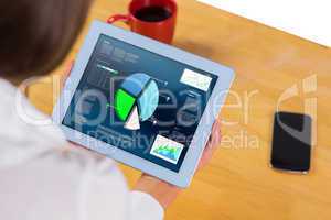 Composite image of businesswoman using tablet at desk