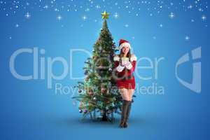 Composite image of pretty girl in santa costume holding gift box