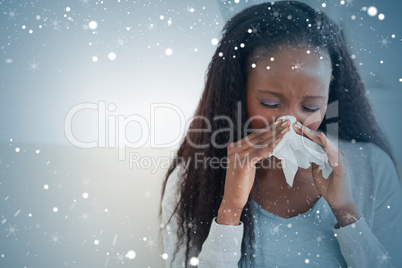 Composite image of close up of woman blowing her nose on couch