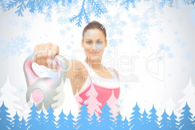 Smiling toned brunette showing grey and pink kettlebell