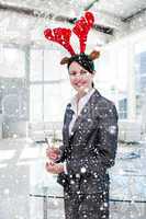 Smiling businesswoman with a novelty christmas hat drinking cham