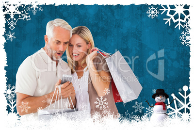 Composite image of happy couple with shopping bags and smartphon