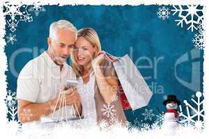 Composite image of happy couple with shopping bags and smartphon