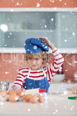 Composite image of nice boy baking in a kitchen