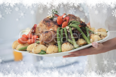 Composite image of woman presenting a roast dinner