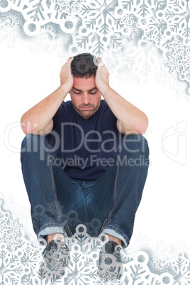 Sitting upset man with head between hands