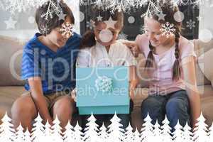 Composite image of happy kids with gift box in living room