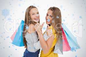 Rear view of two young women the thumbup with shopping bags