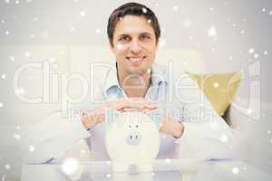 Handsome casual man with piggy bank in living room