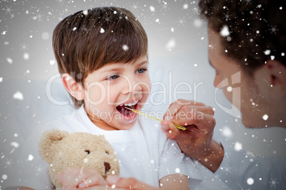 Composite image of positive doctor taking little boys temperatur