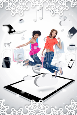 Composite image of two smiling women jumping on a tablet pc