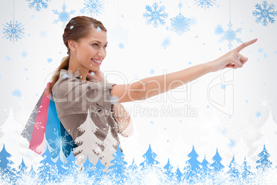 Side view of pointing woman with shopping bags