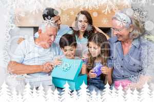 Composite image of extended family sitting on sofa with gift box