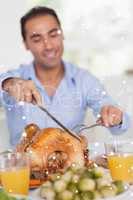 Composite image of man carving turkey at head of table