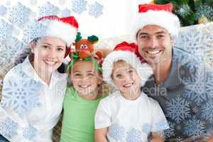 Happy family with christmas hats sitting on the sofa