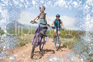 Composite image of athletic couple mountain biking