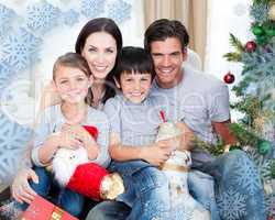 Portrait of a smiling family at christmas time holding lots of p