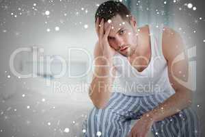 Composite image of depressed man sitting on his bed