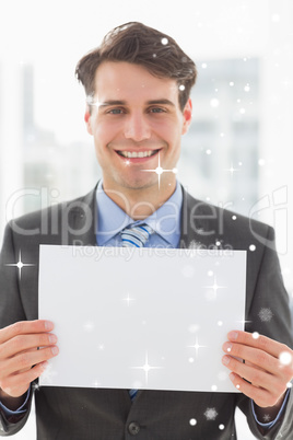 Composite image of happy businessman holding blank page