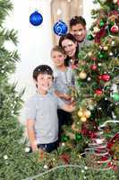 Composite image of happy family decorating a christmas tree with