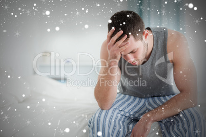 Composite image of sad man sitting on his bed