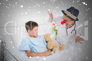 Doctor in clown costume entertaining ill boy in hospital