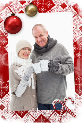 Composite image of happy mature couple in winter clothes holding