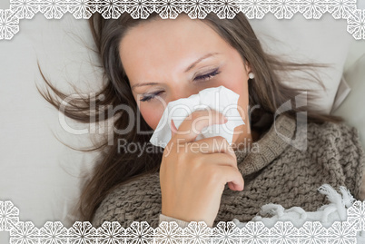 Sick woman lying on sofa and blowing nose