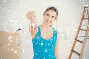 Woman holding out with key besides boxes in new house