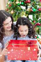 Mother and daughter playing with christmas gifts