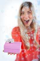 Composite image of astonished woman holding a gift