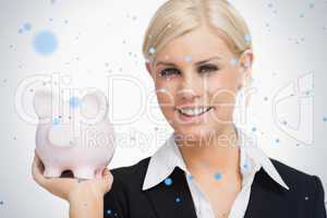 Smiling businesswoman holding a piggybank