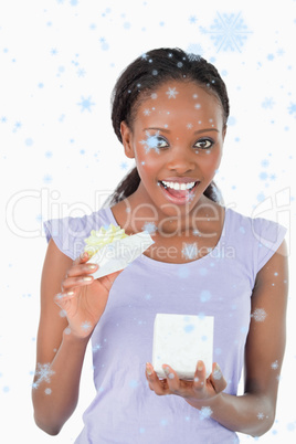 Composite image of close up of happy woman opening a present aga