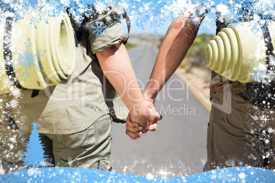 Hitch hiking couple standing holding hands on the road