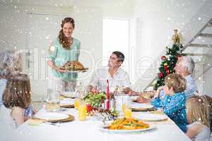 Composite image of mother serving christmas meal to family