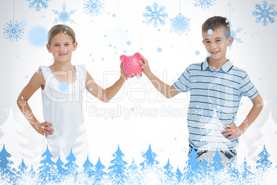 Brother and sister holding piggy bank together