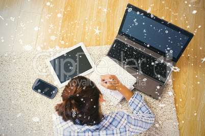 Brunette young student using her tablet and notebook for doing h