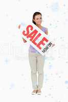 Composite image of young female holding a sales sign