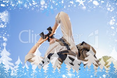 Hiker looking through binoculars on country trail