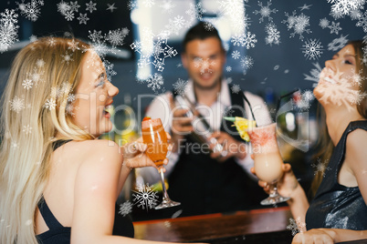 Handsome bartender working while gorgeous friends having cocktai