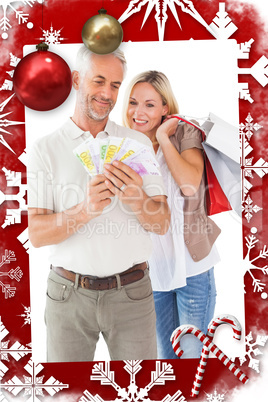 Happy couple holding shopping bags and cash