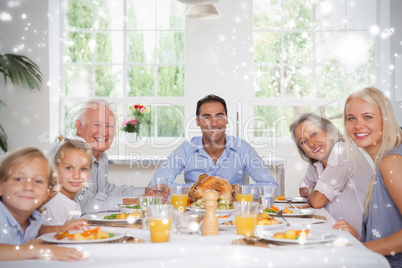 Composite image of family smiling at thanksgiving