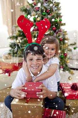 Composite image of happy brother and sister celebrating christma