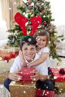 Composite image of happy brother and sister celebrating christma