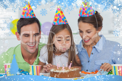 Composite image of little girl blowing out her candles