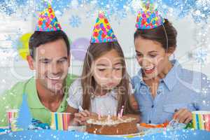 Composite image of little girl blowing out her candles