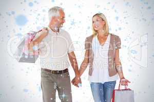 Happy couple holding shopping bags and hands