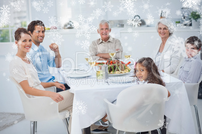 Composite image of family smiling at the dinner table